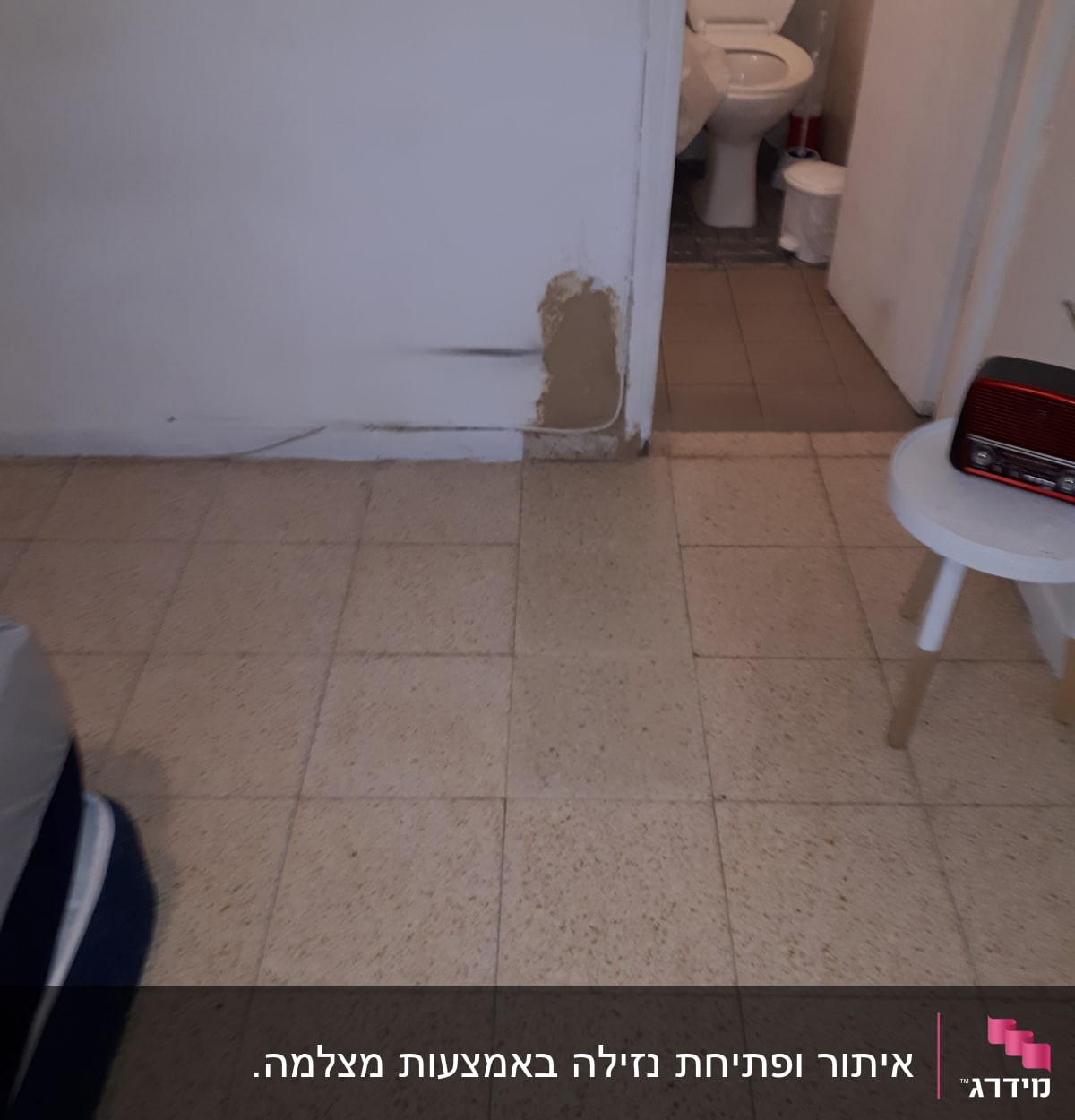 קיר עם סימני רטיבות ותיקון טיח ליד שירותים